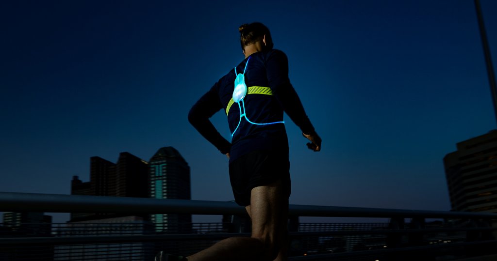 A man running at night with a Tracer2 reflective vest.