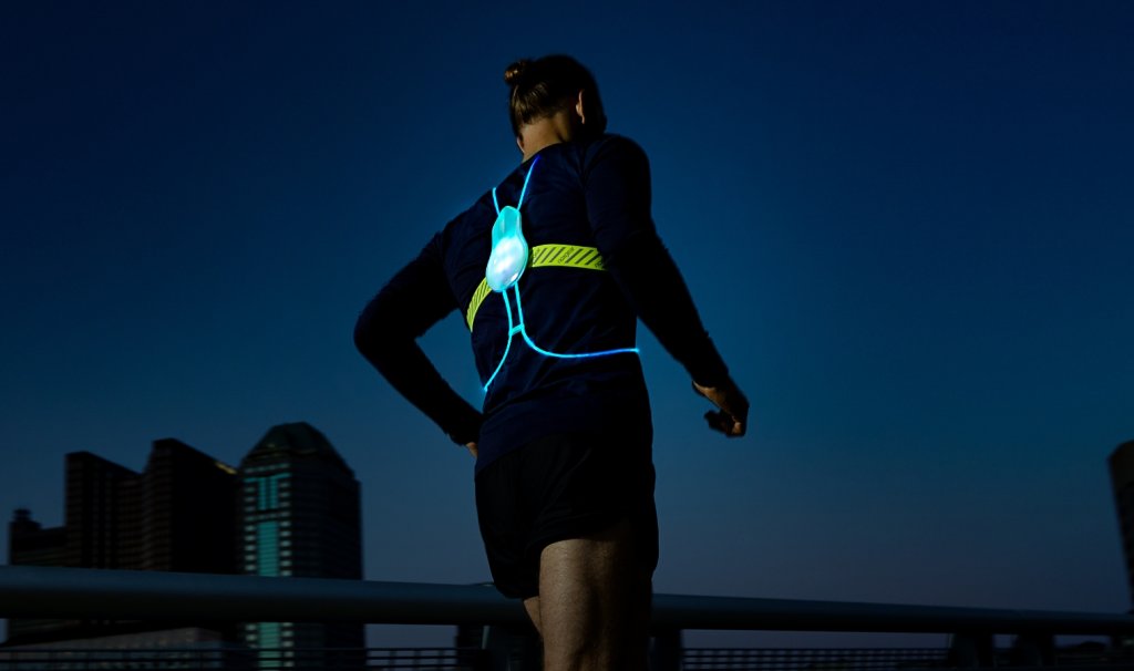 A person running wearing the Tracer2 lit up blue.