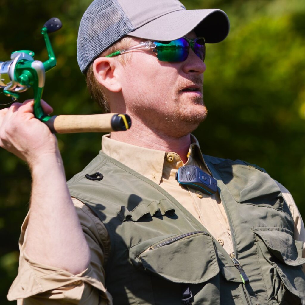 Photo of a man casting a fishing line while wearing a 39g on his shirt.