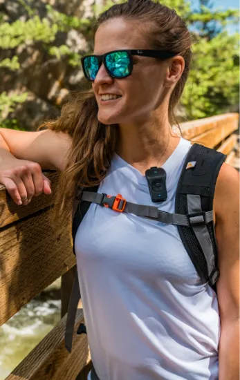 Photo of a woman wearing a hiking backpack while wearing a 39g on her shirt.