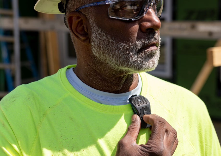 A construction worker wearing a 39g touching the buttons.