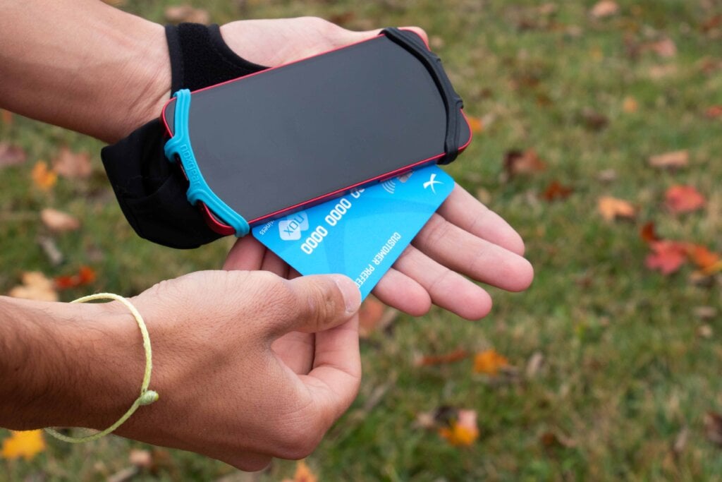 Hand pulling a credit card out of the cardholder in the Phone Holder.