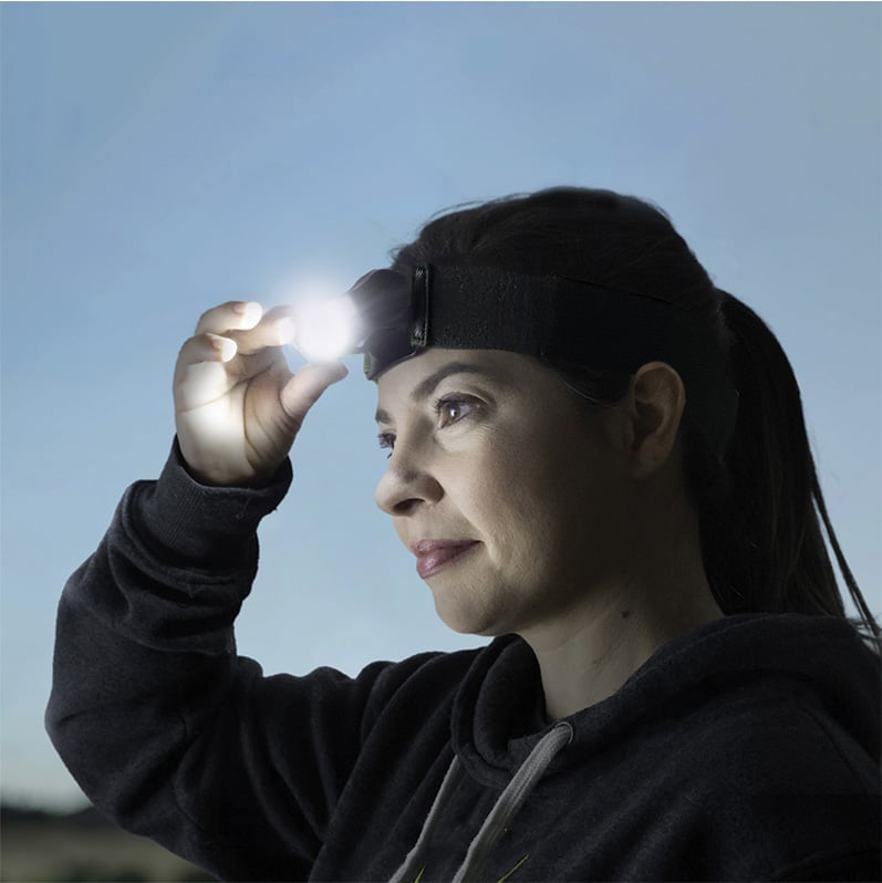 Woman wearing the Head Light adjusting the angle of the lamp.