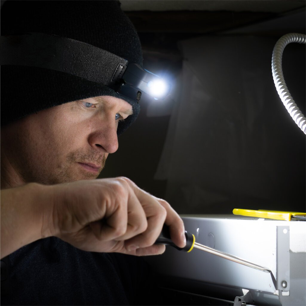 Man using a screwdriver and using the head light to illuminate his work area.