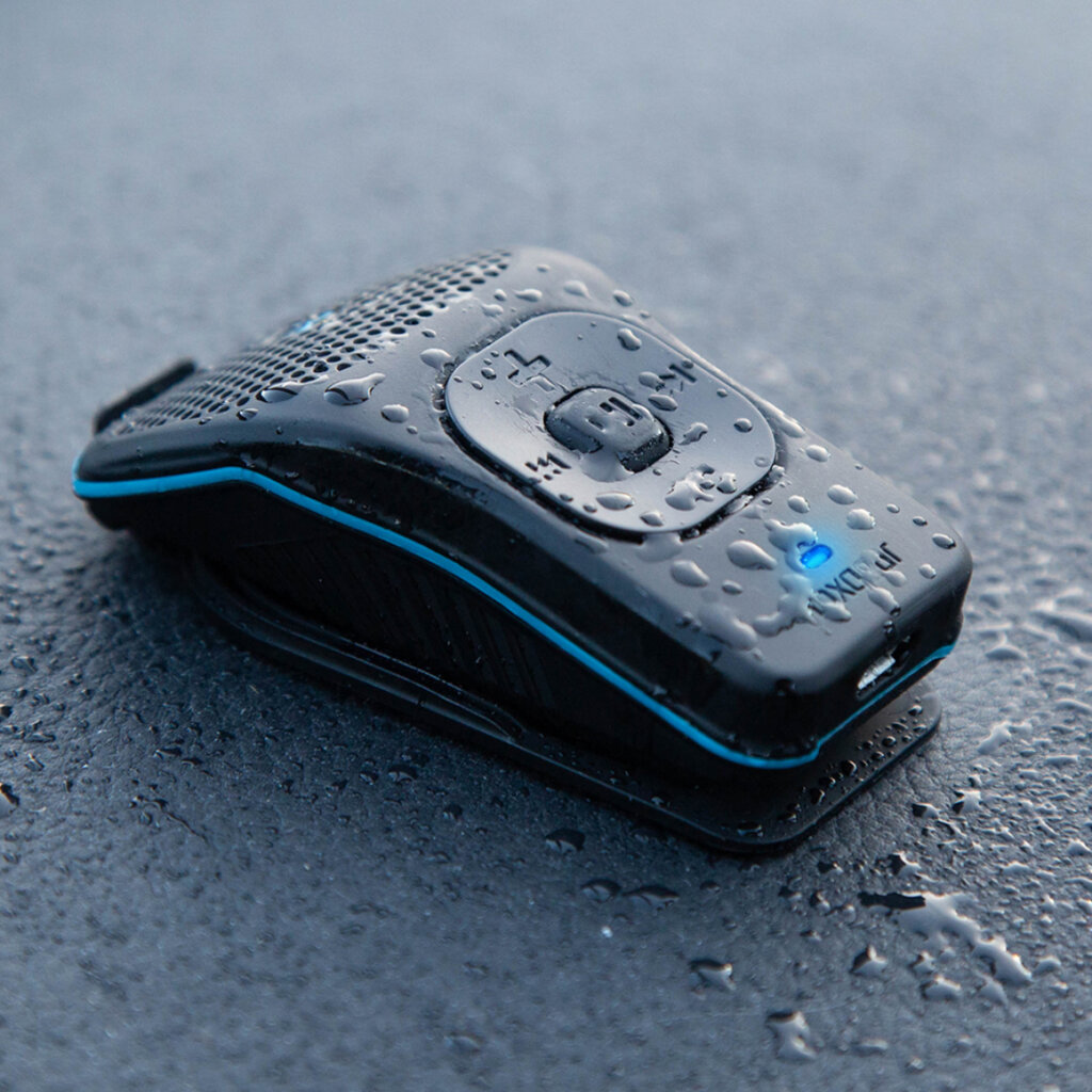 A small device with a blue light sitting on top of a wet surface.