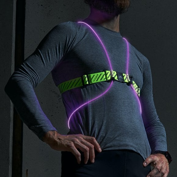 A man in a grey shirt is wearing a neon Tracer2 vest.