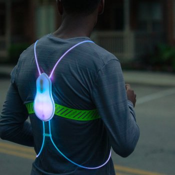 Man wearing a Tracer2 illuminated blue and purple, back to camera.