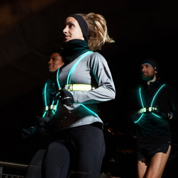 A group of people running in the dark with Tracer360 lights.