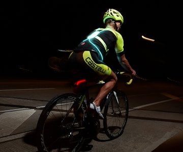 A person riding a bike at night, seeking help.
